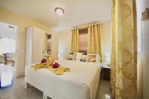 a bedroom with a white bed with flowers on it at Beija Flor Entire home in Oranjestad, Aruba in Paradijs