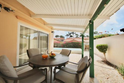 a patio with a table and chairs and a window at Beija Flor Entire home in Oranjestad, Aruba in Paradijs