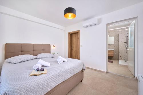 a white bedroom with a bed with towels on it at B&B Dia in Murine
