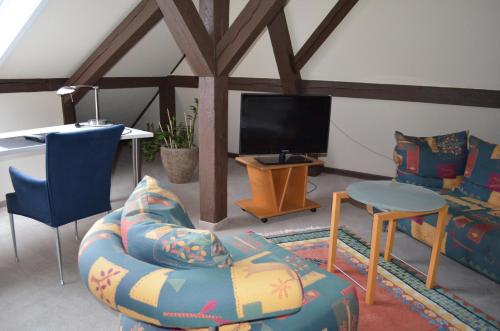 a living room with a couch and a tv at Alte Post - Hotel Am Rhein-Ufer Laufenburg in Laufenburg