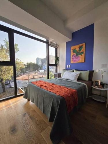 a bedroom with a bed and a large window at Ultimate Getaway in Luxe Studio in Mexico City