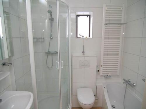 Un baño con ducha, inodoro y lavabo. en Chalet in Texel near Dunes & Water, en De Cocksdorp