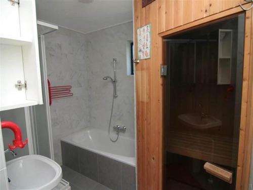 a bathroom with a tub and a toilet and a sink at Chalet in Texel by Dunes and Water in De Cocksdorp