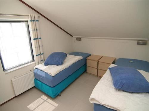 a small room with two beds and a window at Chalet in Texel by Dunes and Water in De Cocksdorp