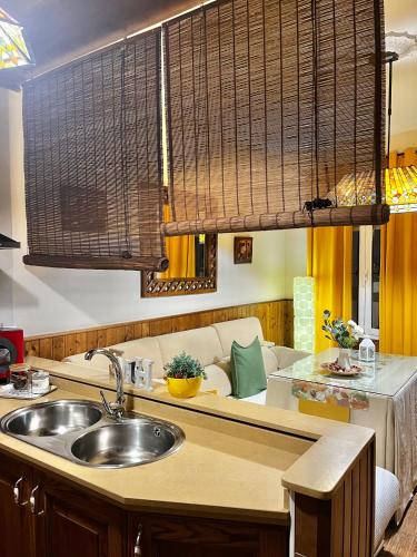 a kitchen with a sink and a couch at Casa Rural Abril in Setenil