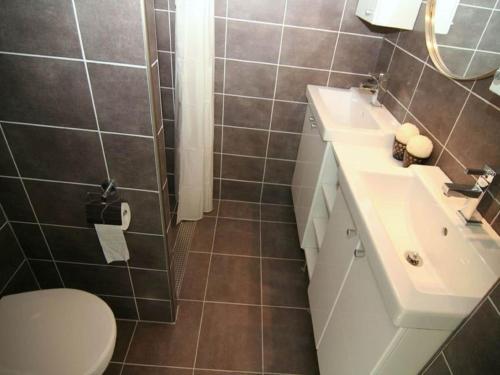 un baño con inodoro y lavabo en Chalet in Texel near Dunes and Water, en De Cocksdorp
