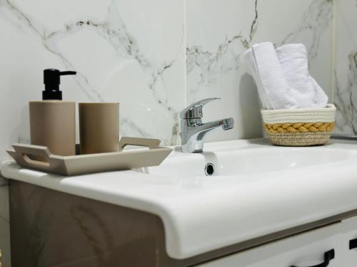 a bathroom sink with a faucet and towels on it at BATUU Luxury Living in Bizerte