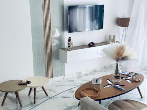 a living room with a table and a tv at BATUU Luxury Living in Bizerte