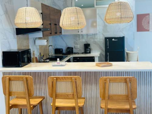 a kitchen with two wooden chairs at a counter at BATUU Luxury Living in Bizerte