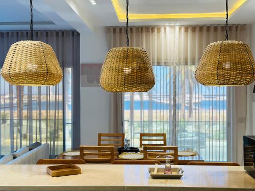 a dining room with two hanging lights and a table at BATUU Luxury Living in Bizerte