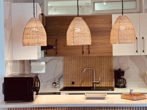 a kitchen with two hanging lights over a sink at BATUU Luxury Living in Bizerte