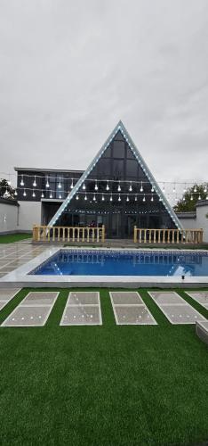 a building with a swimming pool and green grass at Dreamscape Villa in Gabala