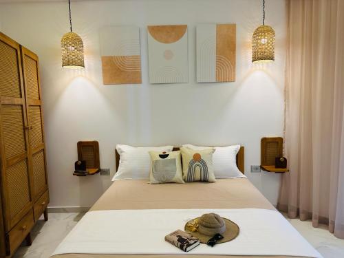 a bedroom with a bed with a hat on it at BATUU Luxury Living in Bizerte