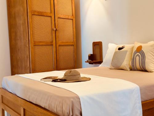 a hat and sunglasses are sitting on a bed at BATUU Luxury Living in Bizerte