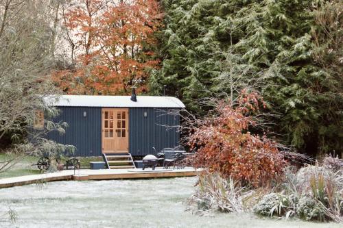 a blue shed with a bench and a table in a garden at Peatlands in Ballybogy