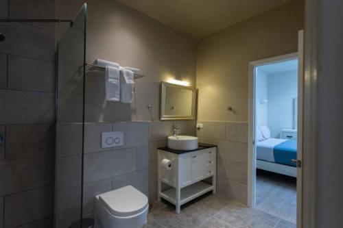 a bathroom with a toilet and a sink and a shower at Dutch Caribbean Residence D in Palm-Eagle Beach