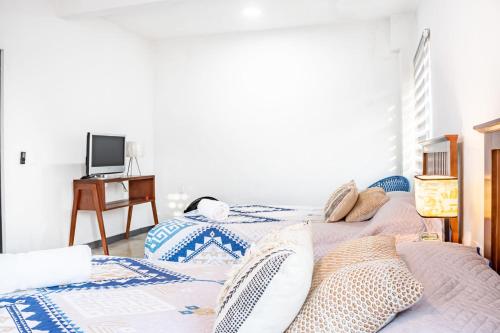 two twin beds in a room with a desk at Vida Casa Kuxtal Rooftop con vista al Lago in Vista Hermosa