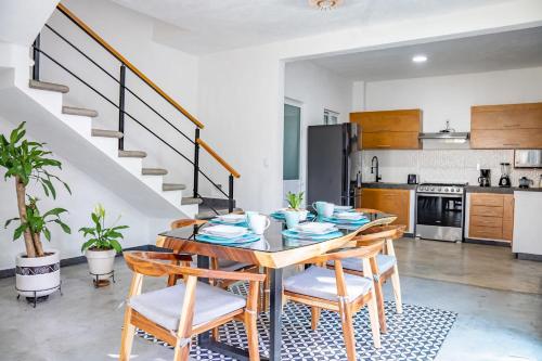 a kitchen and dining room with a table and chairs at Vida Casa Kuxtal Rooftop con vista al Lago in Vista Hermosa