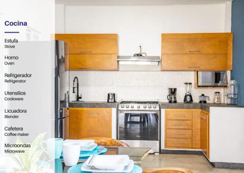 a kitchen with wooden cabinets and stainless steel appliances at Vida Casa Kuxtal Rooftop con vista al Lago in Vista Hermosa