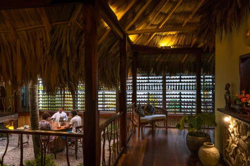 a group of people sitting at a table in a restaurant at Turtle Inn by Francis Ford Coppola in Placencia Village