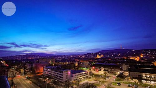 a view of a city at night at Sky Panorama Apartman Pécs in Pécs