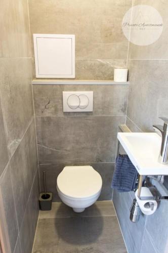 a bathroom with a toilet and a sink at Sky Panorama Apartman Pécs in Pécs