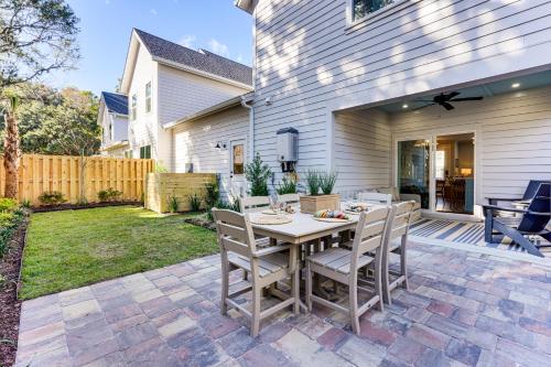 a backyard patio with a wooden table and chairs at Historic Location Townhome in Johns Island! in Johns Island
