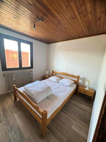 une chambre avec un grand lit avec un plafond en bois dans l'établissement Résidence Marmottes - APPARTEMENT 3 PIECES ALPE D'HUEZ CENTRE STAITON MAE-2781, à Huez