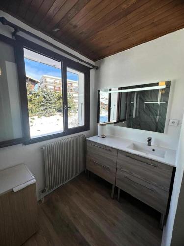 une salle de bain avec un lavabo, un miroir et une fenêtre dans l'établissement Résidence Marmottes - APPARTEMENT 3 PIECES ALPE D'HUEZ CENTRE STAITON MAE-2781, à Huez
