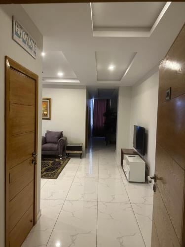 a hallway with a living room with a couch and a television at *Designer’s Luxurious 1BHK at Top Location of Twin Cities!! in Rawalpindi