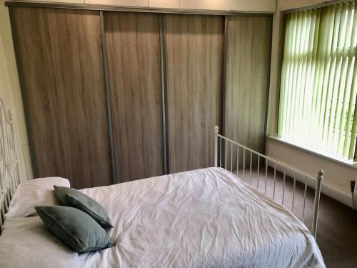 a bedroom with a bed with two pillows on it at Cheerful 2 bedroom town house in Lancashire in Chorley