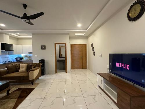 a living room with a couch and a tv at *Designer’s Luxurious 1BHK at Top Location of Twin Cities!! in Rawalpindi