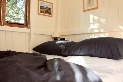 a bed with two black pillows on top of it at Peatlands in Ballybogy