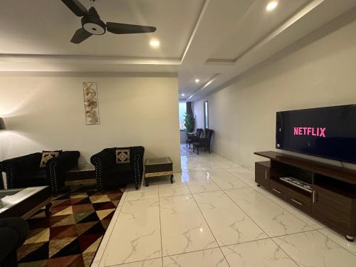 a living room with a tv and a couch at *Designer’s Luxurious 1BHK at Top Location of Twin Cities!! in Rawalpindi