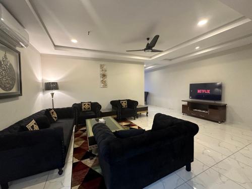 a living room with couches and a flat screen tv at *Designer’s Luxurious 1BHK at Top Location of Twin Cities!! in Rawalpindi