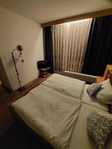 a bedroom with a large bed and a window at Goldner Engel, Restaurant - Hotel - Metzgerei in Laudenbach