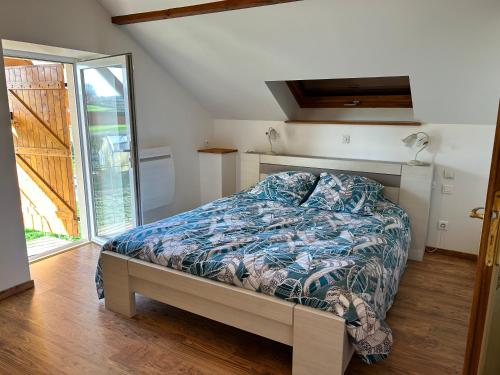 a bedroom with a bed and a large window at LE PERRIER Chambres d'hôtes in Ciry-le-Noble