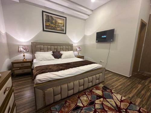 a bedroom with a large bed and a flat screen tv at *Designer’s Luxurious 1BHK at Top Location of Twin Cities!! in Rawalpindi