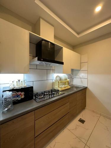 a kitchen with a stove top and a microwave at *Designer’s Luxurious 1BHK at Top Location of Twin Cities!! in Rawalpindi