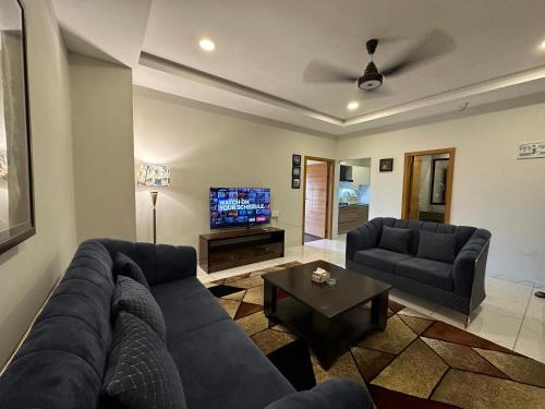 a living room with a couch and a tv at *Designer’s Luxurious 1BHK at Top Location of Twin Cities!! in Rawalpindi