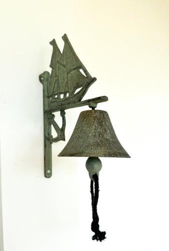 a metal bell hanging on a wall at Swallow's Perch Guest Suite in Vesuvius
