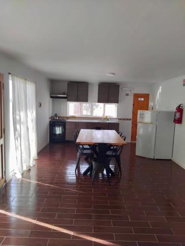 a kitchen with a table and chairs and a refrigerator at Hospedaje la Florentina in Pica