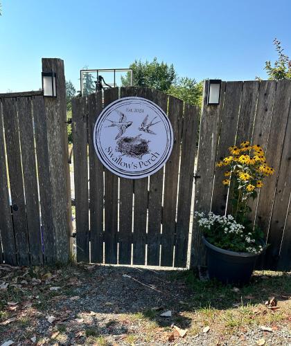 a wooden fence with a sign on it at Swallow's Perch Guest Suite in Vesuvius