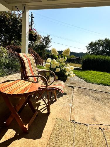 a wooden bench and a table on a patio at Swallow's Perch Guest Suite in Vesuvius