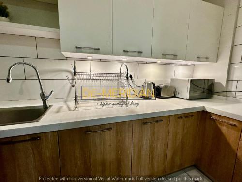 a kitchen with a sink and a dish rack on the counter at *Designer’s Luxurious 1BHK at Top Location of Twin Cities!! in Rawalpindi