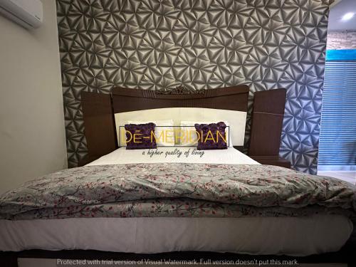 a bedroom with a bed with a be megan pillow on it at *Designer’s Luxurious 1BHK at Top Location of Twin Cities!! in Rawalpindi