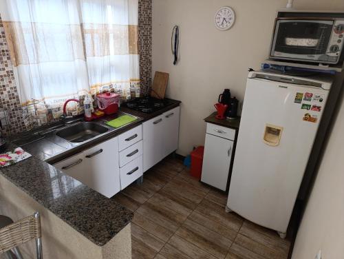 eine kleine Küche mit Kühlschrank und Spüle in der Unterkunft Casa Müller - Veraneio Imbé in Imbé