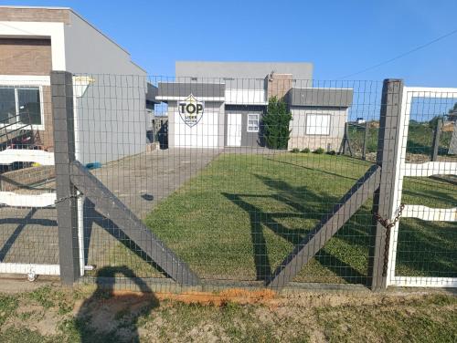 Ein Zaun mit einem Hundepark dahinter. in der Unterkunft Casa Müller - Veraneio Imbé in Imbé