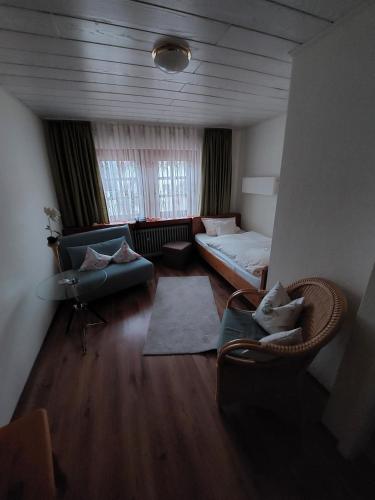 a living room with a couch and a bed and chairs at Goldner Engel, Restaurant - Hotel - Metzgerei in Laudenbach