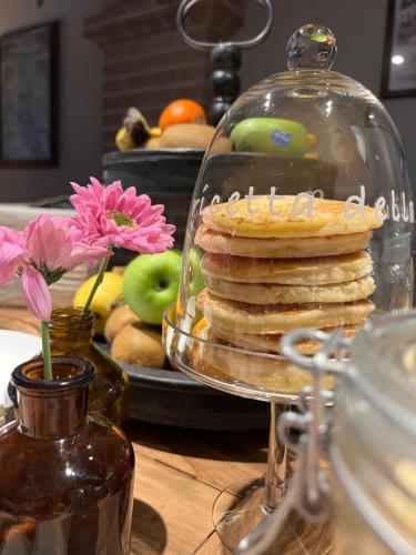 a glass dish with a stack of pancakes on a table at B&B Al Felcino in Fabro